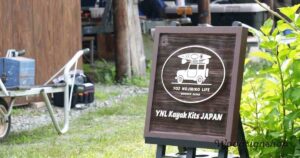 国産杉材で仕上げた木製看板。中央にカヤックを車に載せたロゴと「YOZ NOJIRIKO LIFE WOODEN KAYAK」の文字。下部に「YNL Kayak Kits JAPAN」と記されている。