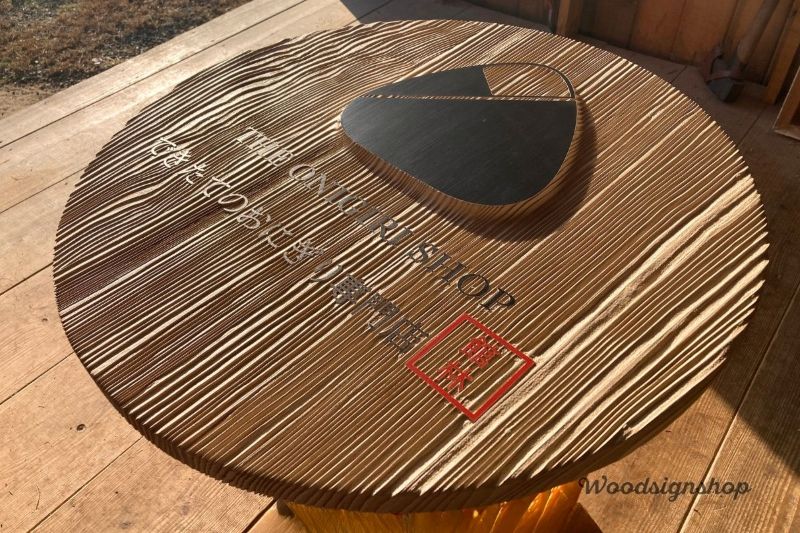 木製看板の明朝体文字が「凹」で彫り込まれている部分のクローズアップ。「館林」の文字は赤色の落款風デザインで強調されている。