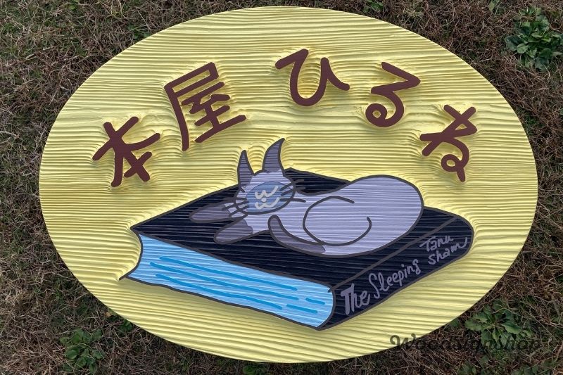 サンドブラストによる浮き彫り加工で製作した「本屋ひるね」様の楕円形木製看板。