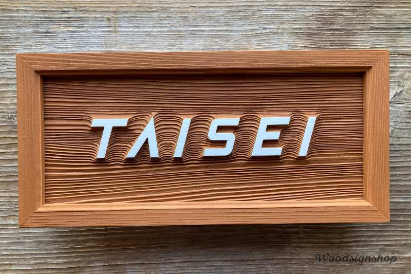 サンドブラスト加工を施した木製看板の正面写真。立体文字TAISEIを配置した卓上用ウッドサイン。