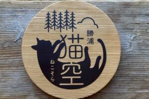 千葉県勝浦市の民泊施設「勝浦 猫空」様の杉材を使用した直径40cmの丸型木製看板。猫と杉の木と空のロゴをサンドブラストしたオーダーメイドサイン。