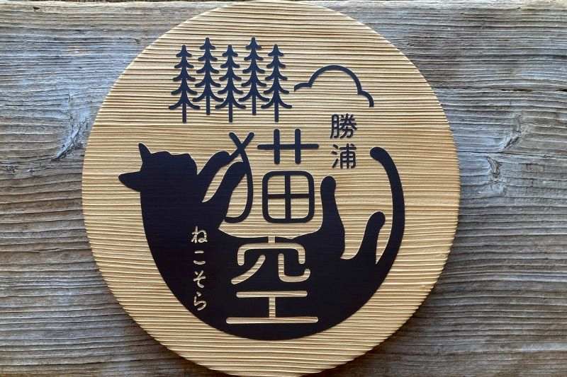千葉県勝浦市の民泊施設「勝浦 猫空」様の杉材を使用した直径40cmの丸型木製看板。猫と杉の木と空のロゴをサンドブラストしたオーダーメイドサイン。