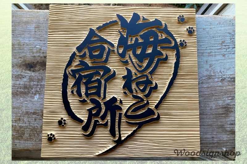 茨城県鉾田市の貸切別荘「海ねこ合宿所」の正方形木製看板。黒文字のロゴと肉球があしらわれたデザイン。