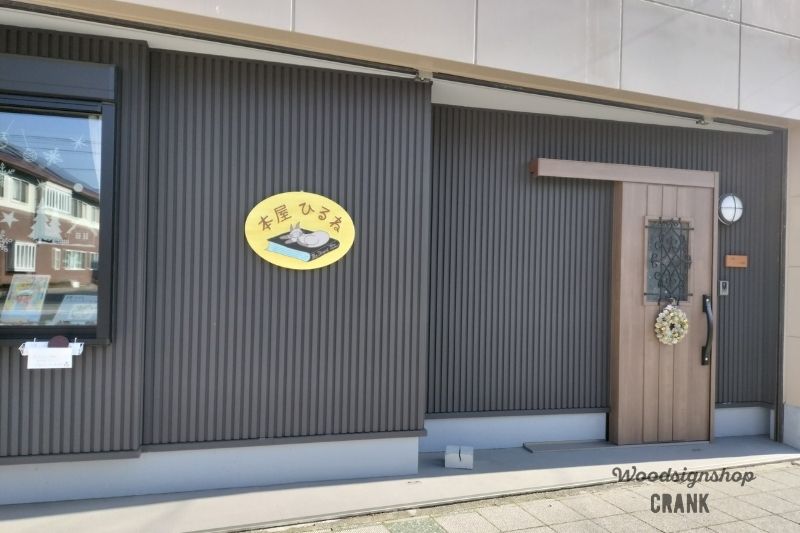 本屋ひるね外観。木製看板と木製表札が店舗前面に設置されている様子