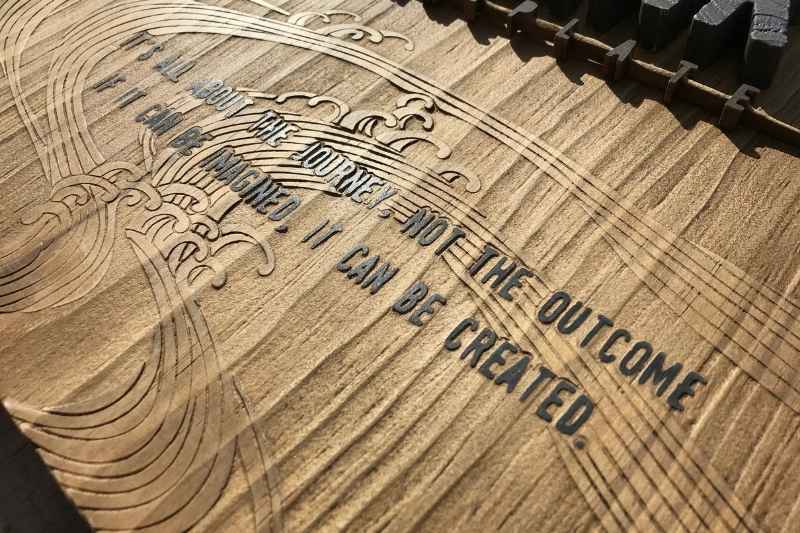木の台座に彫った北斎風の波模様と、「It's all about the journey, not the outcome. If it can be imagined, it can be created.」の英文